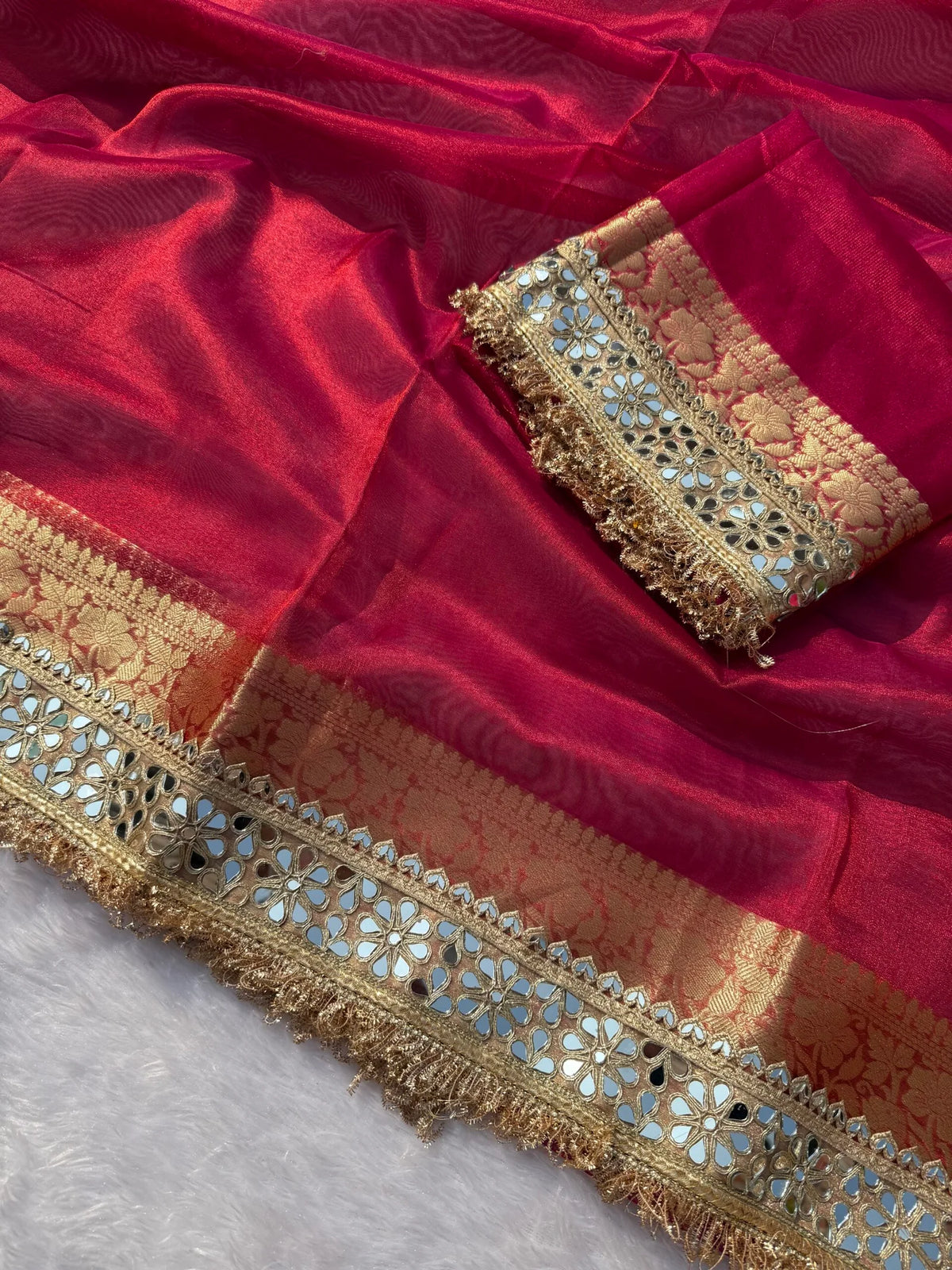 Magenta pink tissue saree with ornate gold, teal and red panel borders