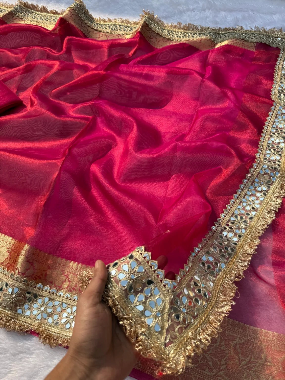 Magenta pink tissue saree drape with wide gold and teal embroidered edge
