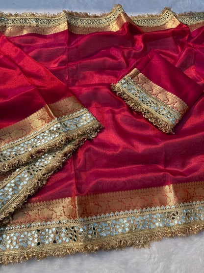 Magenta pink tissue saree with gold and teal embroidered borders and tassel trim