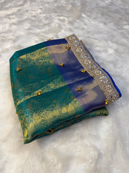 Multi-tone gungroo tissue saree folded view with silver border and decorative edging.