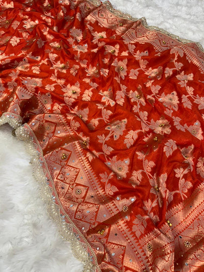 Coral-red saree drape with scattered floral and geometric pattern plus glittery border