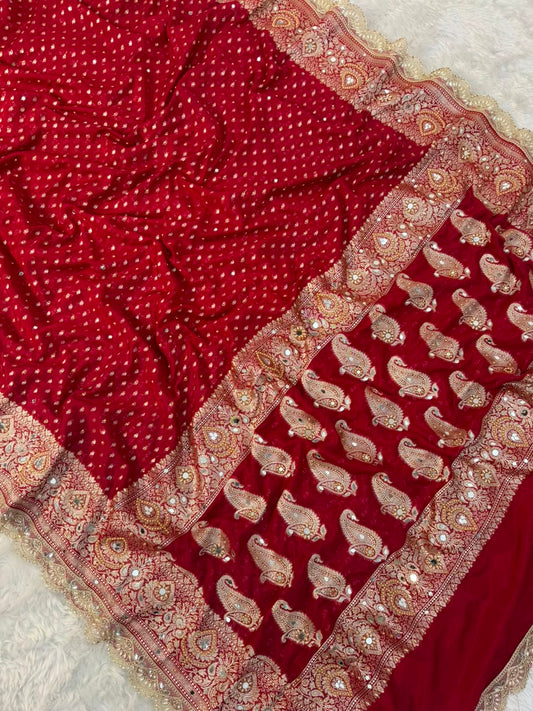 Red saree drape with gold mirror-work trim and ornate pallu border