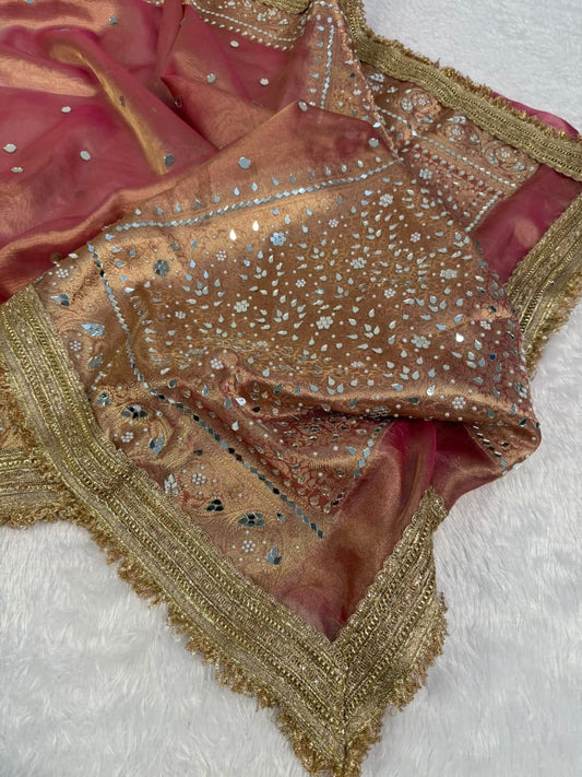 Maroon tissue saree with ornate gold-edged border and blue mirror embellishment