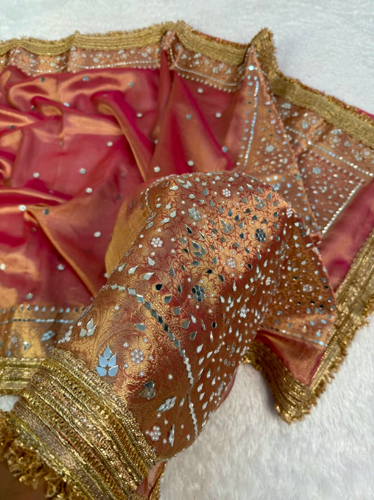 Maroon tissue saree with gold border and dense blue mirror work pallu