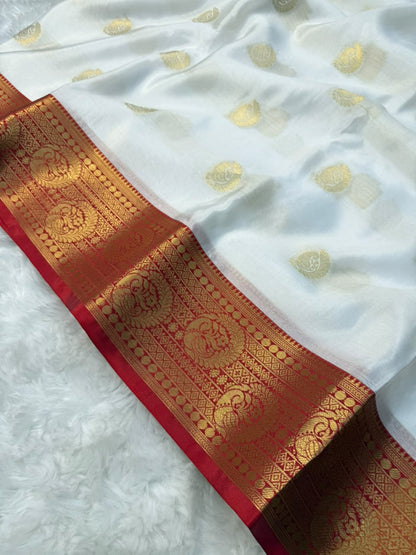 White tapeta saree close-up with gold dots and ornate red-gold zari border strip