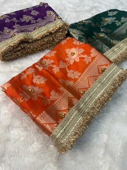 Warm silk gungroo saree in bright orange with gold floral pattern and fringed border.